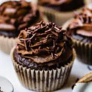 chocolate cupcake with buttercream frosting and chocolate sprinkles on a marble board