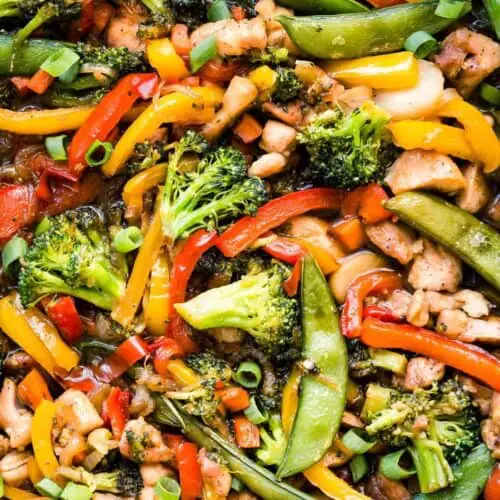 close of chicken stir fry with broccoli, bell peppers, snap peas and carrots