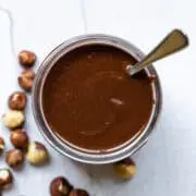 Nutella in a glass jar with a spoon inside