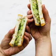 avocado and tuna salad in a sandwich being held