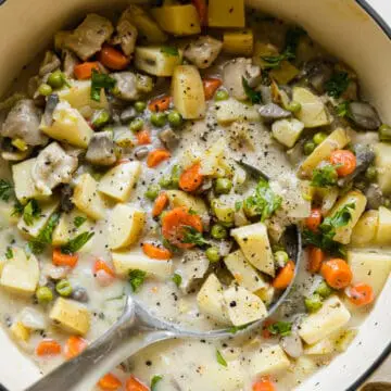 big pot of chicken pot pie soup with veggies and a ladle inside