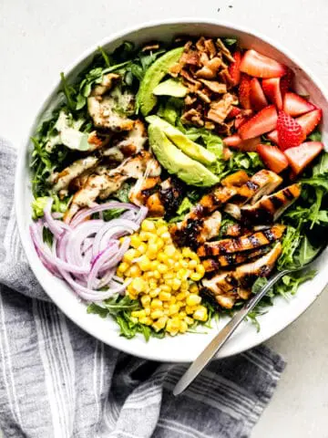 honey mustard chicken salad with avocado, onions, and corn in a large bowl