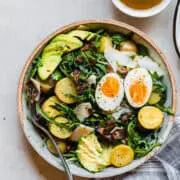 salad with eggs, avocado, potatoes, and bacon on a plate