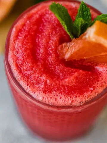 frozen watermelon paloma garnished with mint and a watermelon wedge