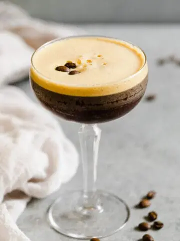 espresso martini in a glass with foam and espresso beans on top