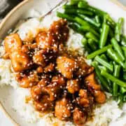 honey butter chicken with green beans and white rice on a plate with a fork