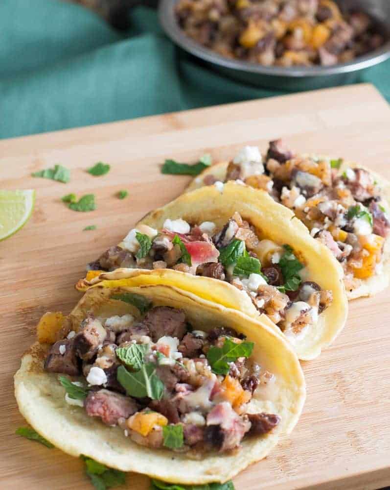 Mediterranean Tacos on a wooden board with fresh herbs