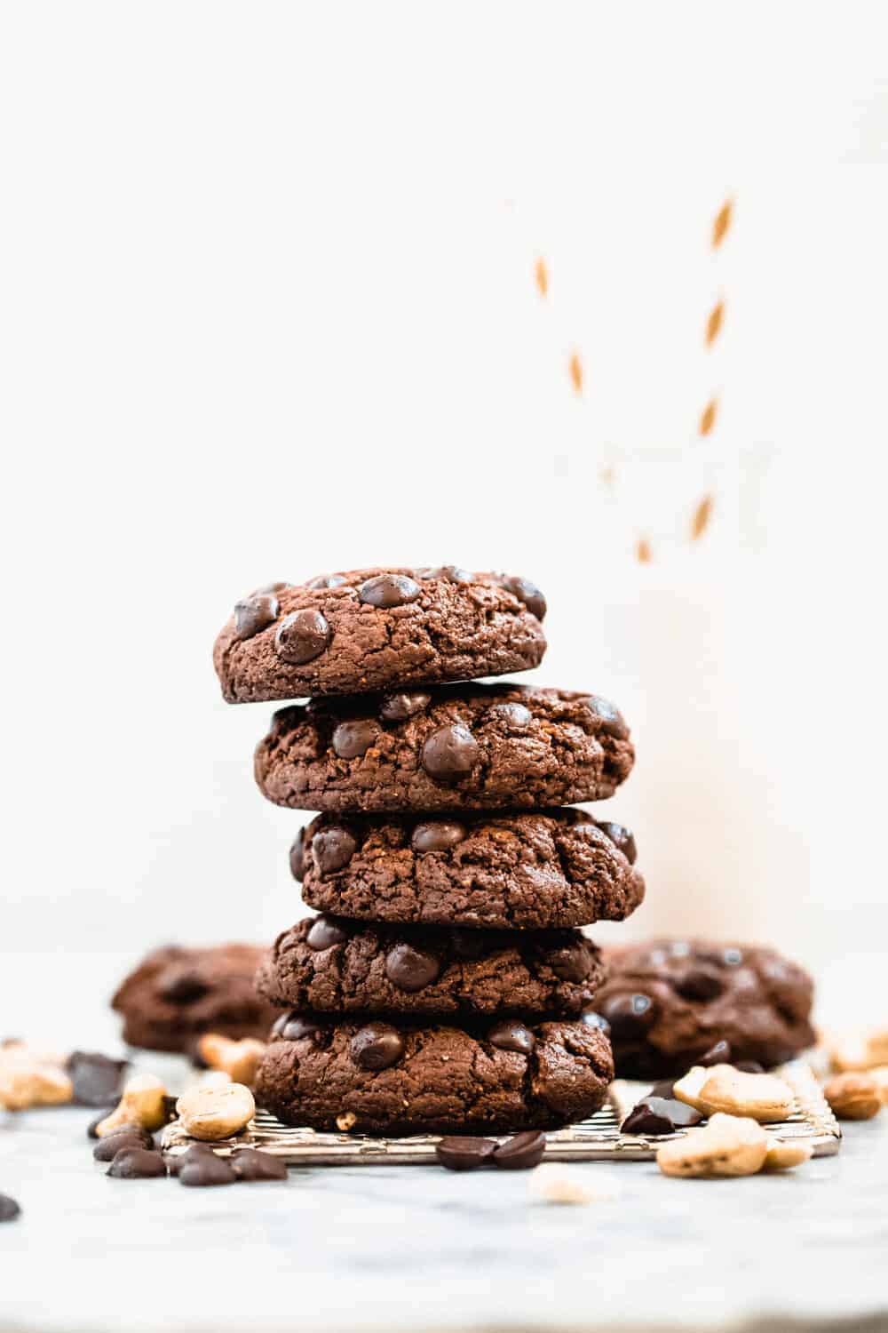 Chocolate chip cookies stacked with nuts and chocolate chips