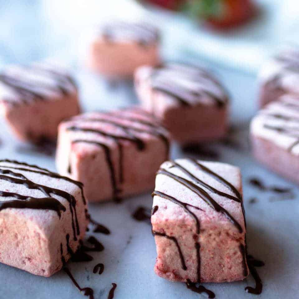 This homemade recipe for Chocolate Drizzled Strawberry Marshmallows is absolutely heavenly. They are quite easy to make and delicious melted between cookies, in a cup of hot chocolate or better yet... BY THEMSELVES! TheMovementMenu.com