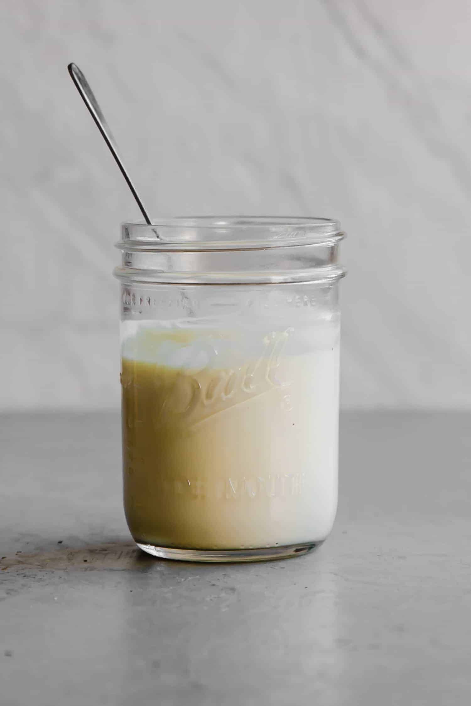 a jar of homemade paleo mayo in a glass jar with a spoon