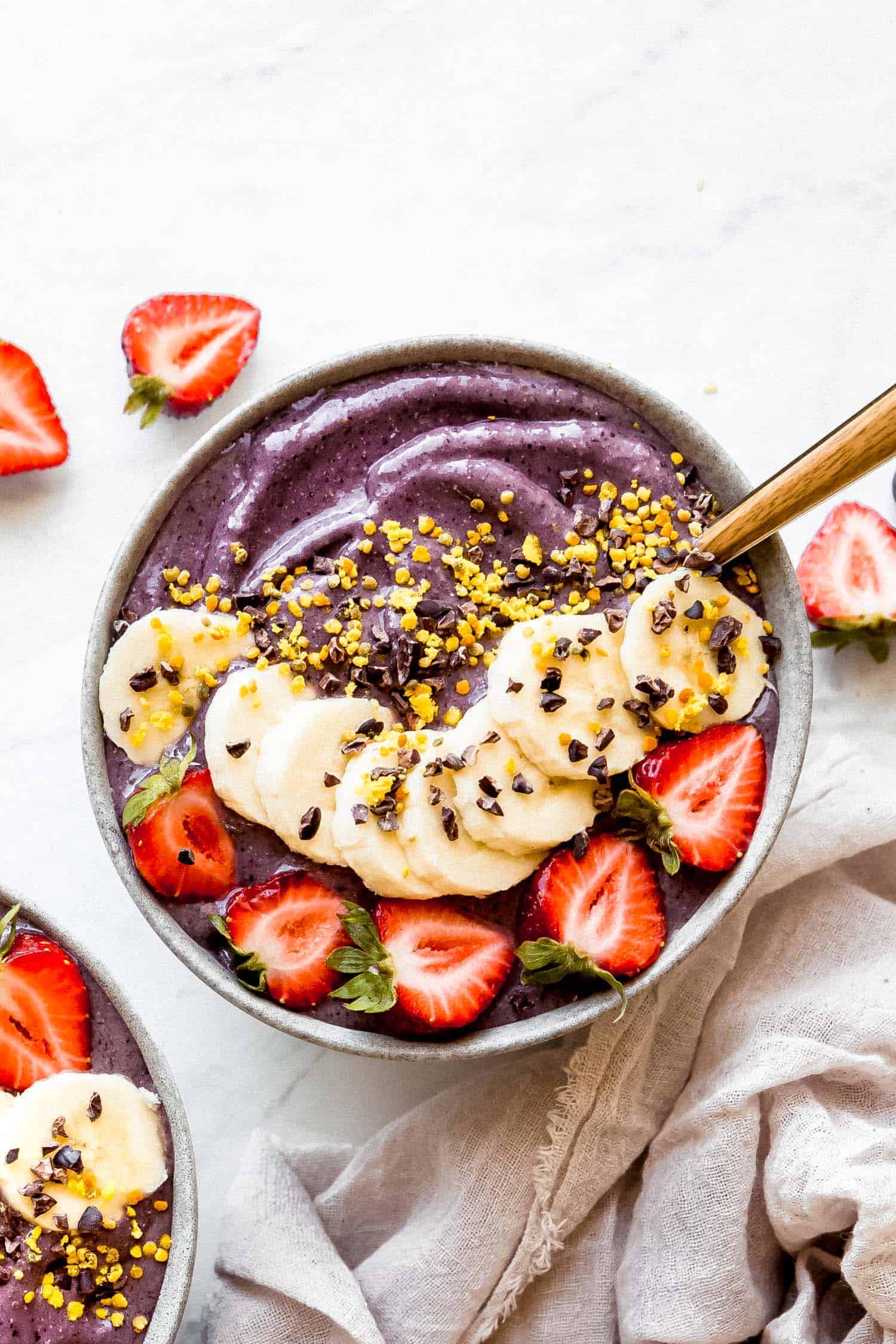 a creamy and vegan acai bowl with toppings and strawberries