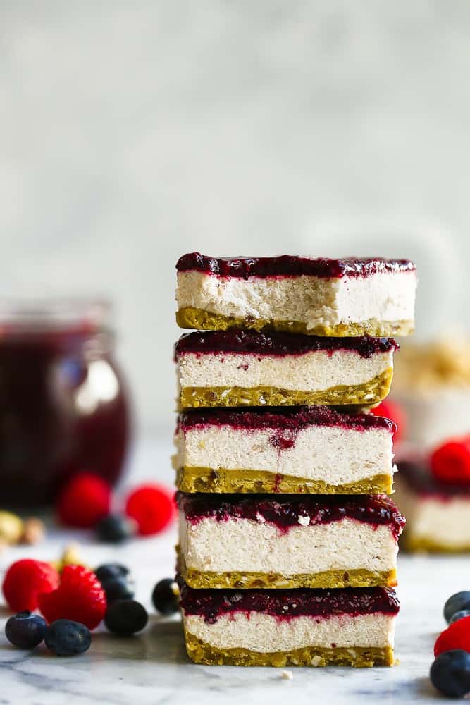 Paleo Vegan Berry Cheesecake Bars stacked on top of each other