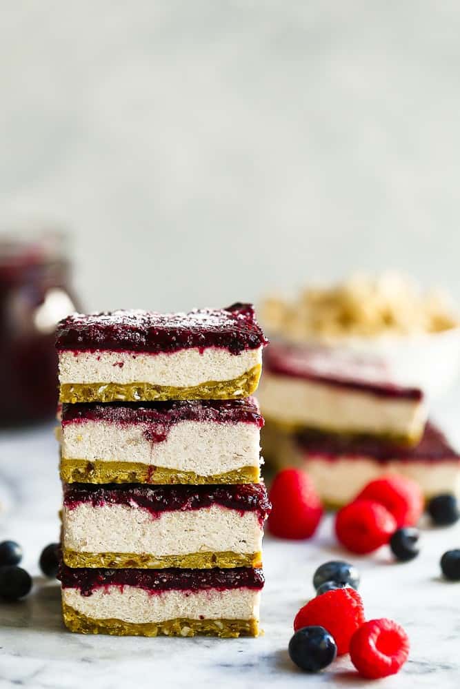 Paleo Vegan Berry Cheesecake Bars with fresh raspberries and blueberries