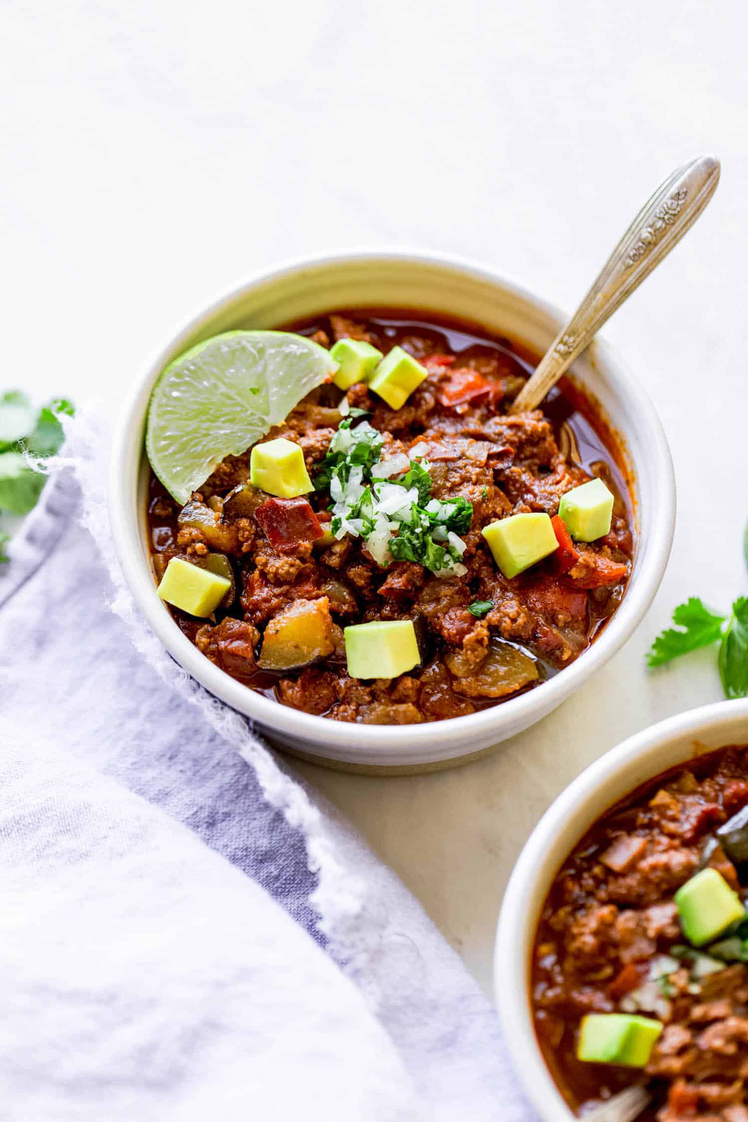 a bowl of whole30 chili with lime on top and a spoon inside