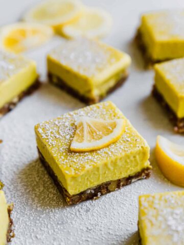 lemon bars with powdered sugar and fresh lemon sliced on top