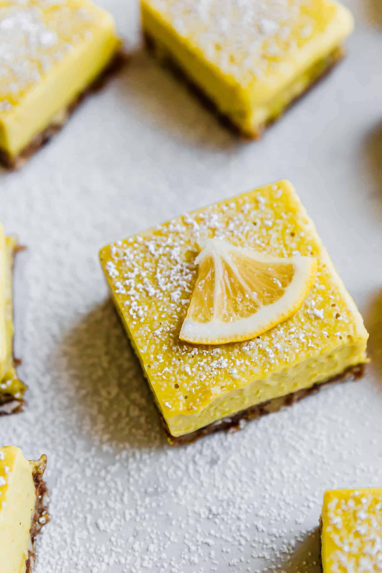paleo lemon bars topped off with powdered sugar and sliced lemon on top