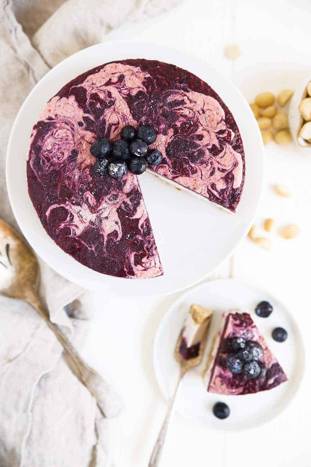 Blueberry Cheesecake on a cake stand with a slice missing