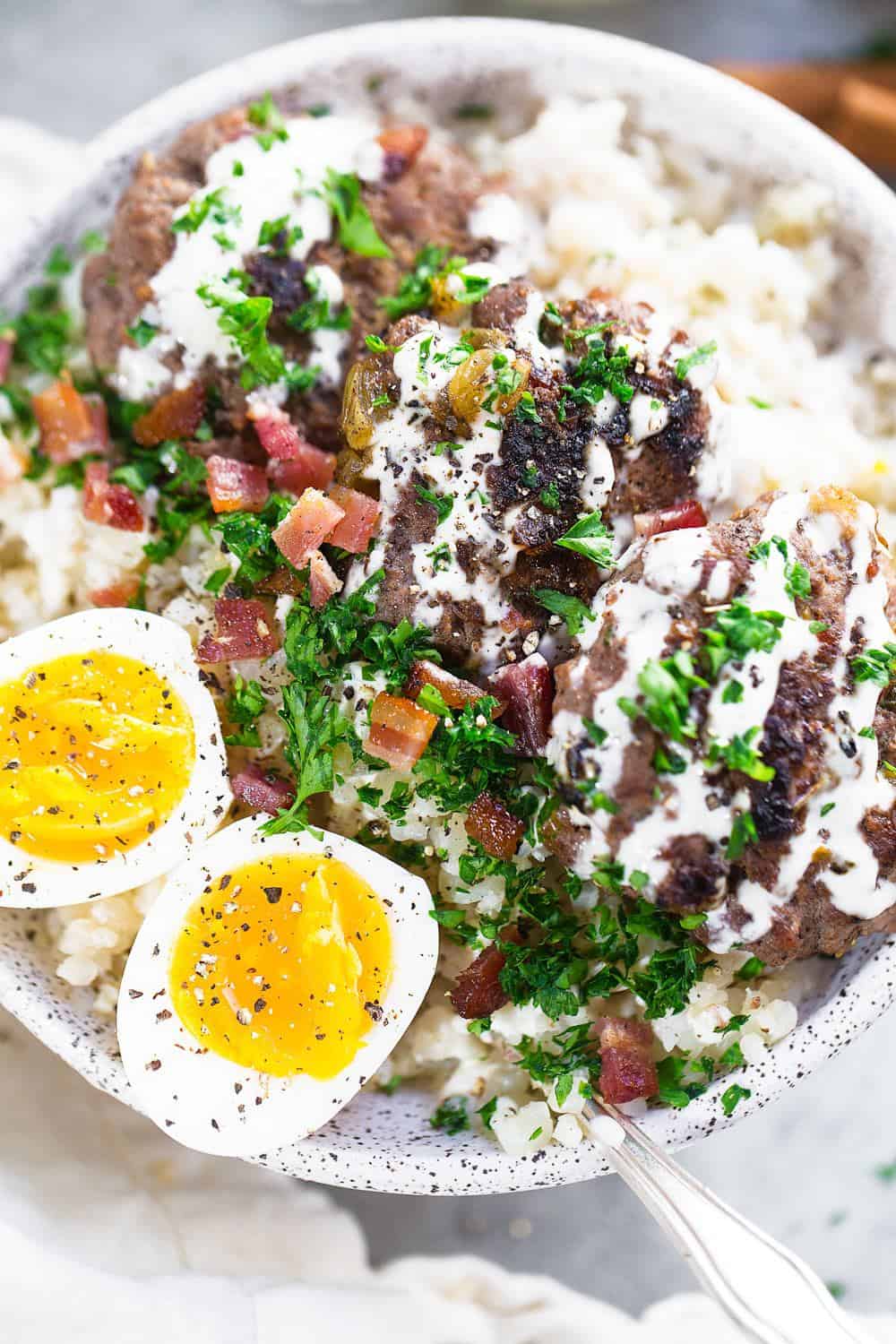 Beef and Bacon Breakfast Bowl garnished with sliced herbs