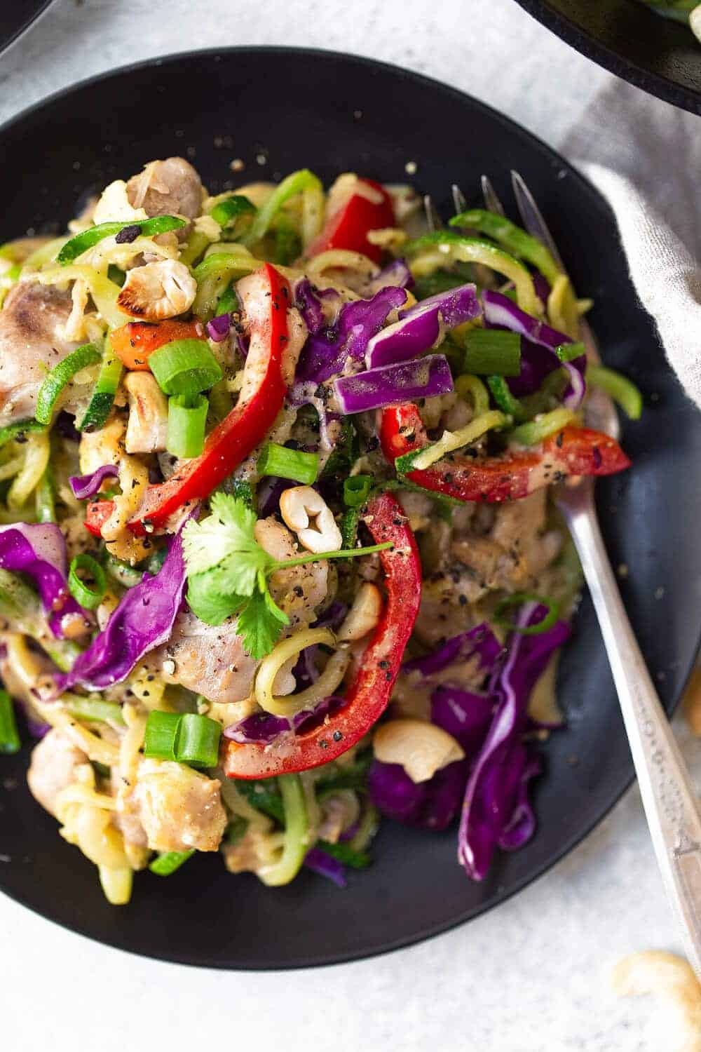 Whole30 Chicken Pad Thai on a black plate with a fork 