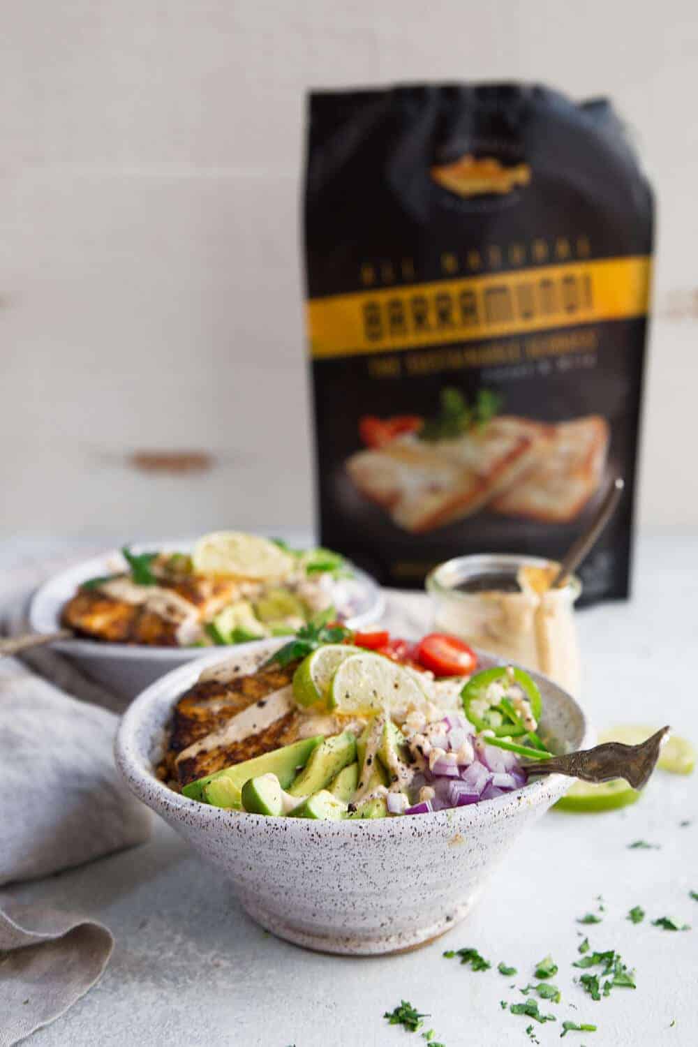 Two paleo fish taco bowls with a packet of barramundi