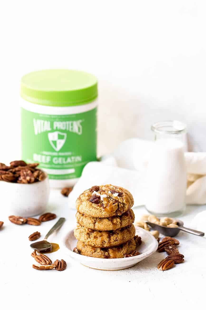 Salted Caramel Pecan Cookies in a bowl with nuts and a jug of milk next to it