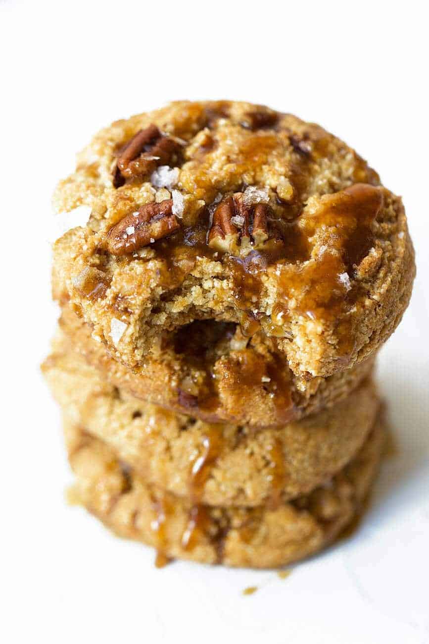 Salted caramel pecan cookies with caramel sauce drizzled down them