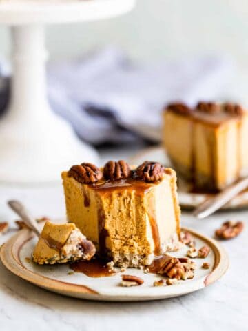 pumpkin cheesecake topped off with caramel on a plate with a fork