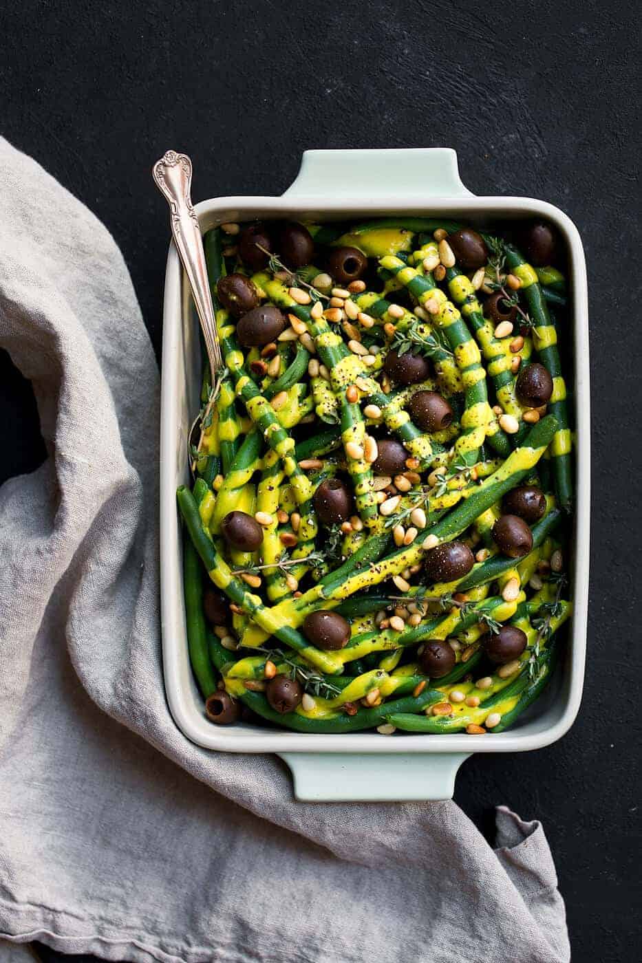 Green beans with olives, pine nuts and fresh thyme in a serving dish