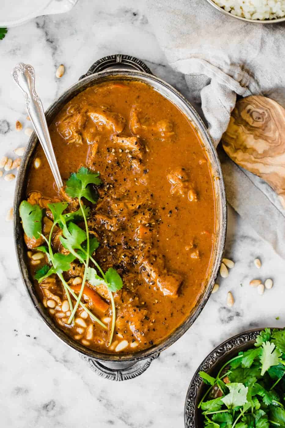 Whole30 Chicken Korma in an oval serving dish with a spoon