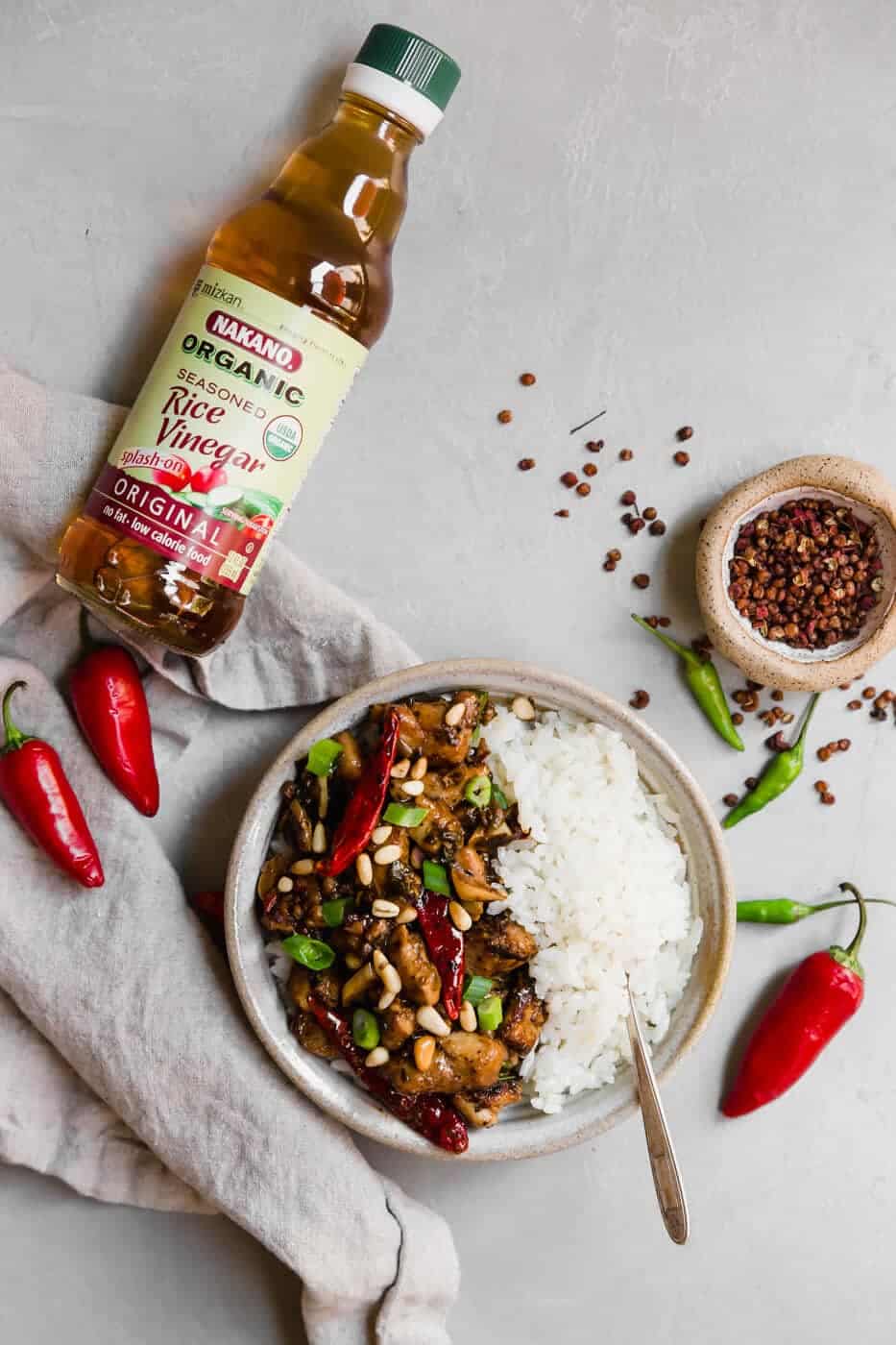 Paleo Kung Pao Chicken with white rice and a bottle of rice vinegar
