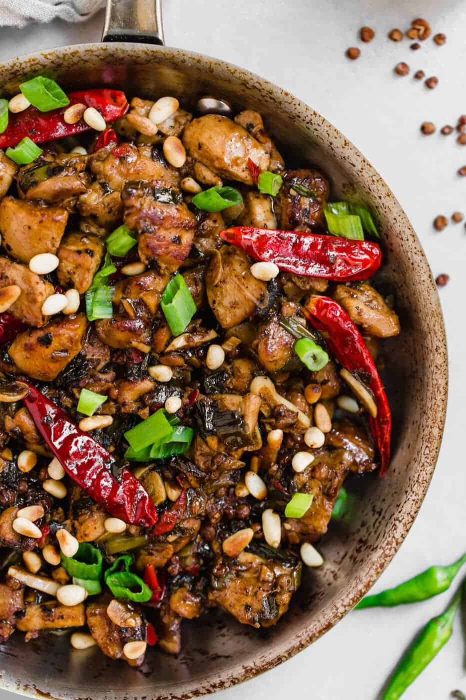 Paleo Kung Pao Chicken with pine nuts, green onions and dry chillies on top