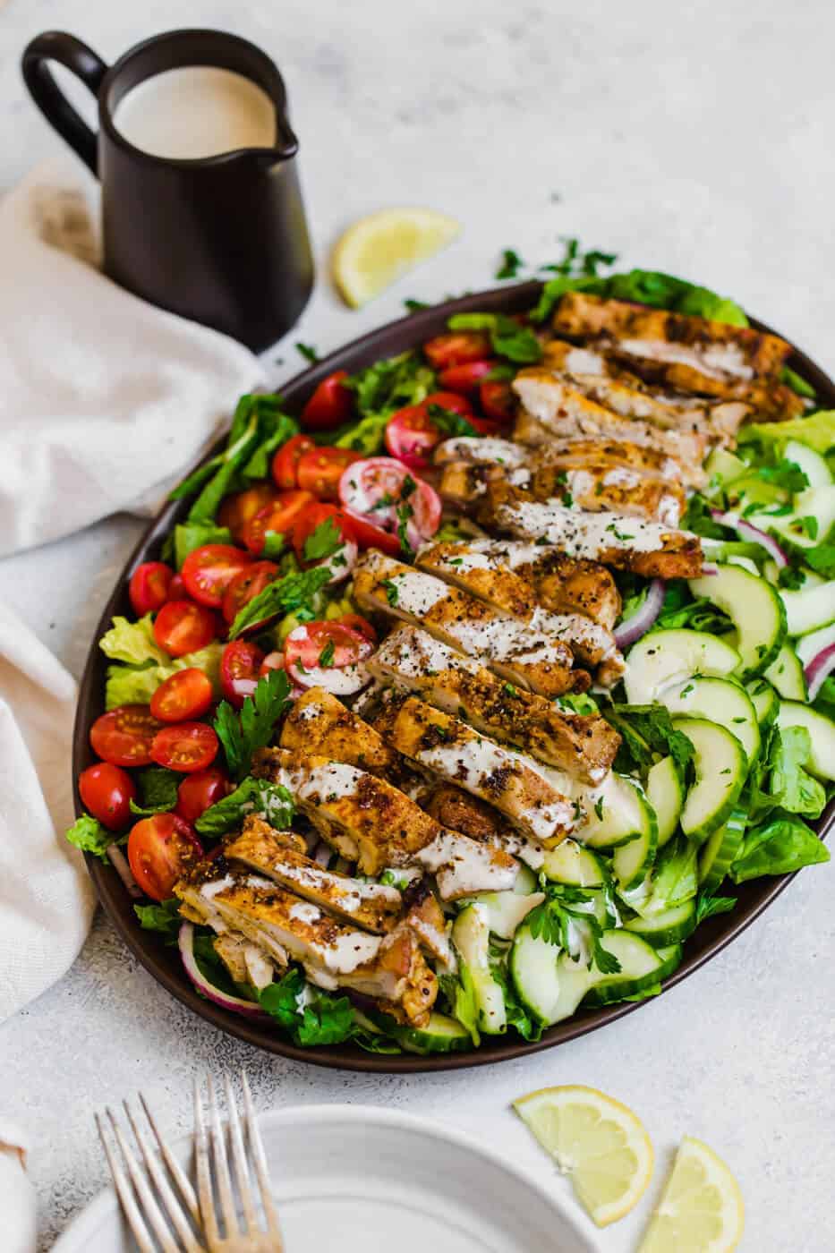 Chicken Shawarma Salad in a serving plate with tahini dressing on the side