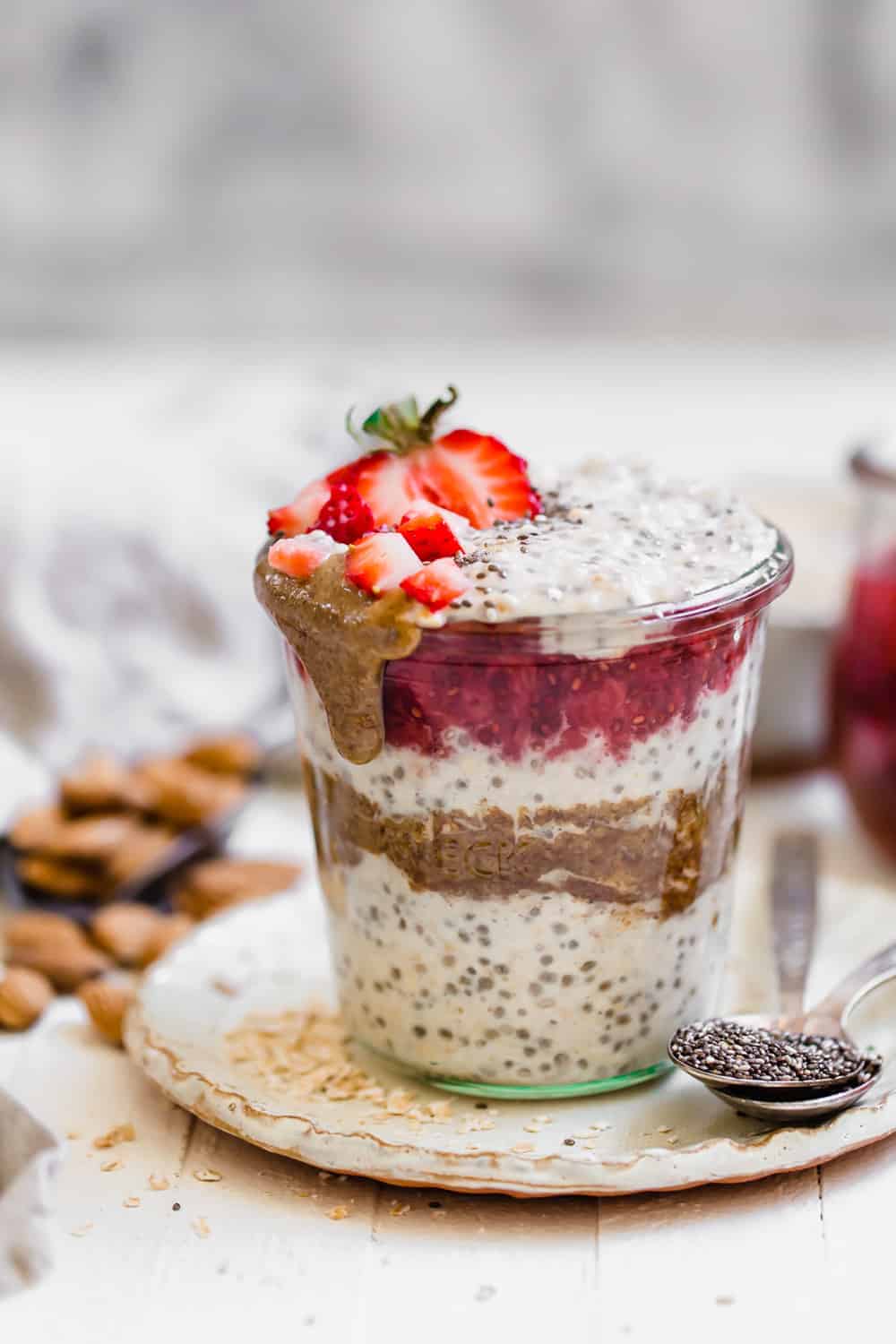 close up shot of overnight oats in a jar with almond butter and strawberries