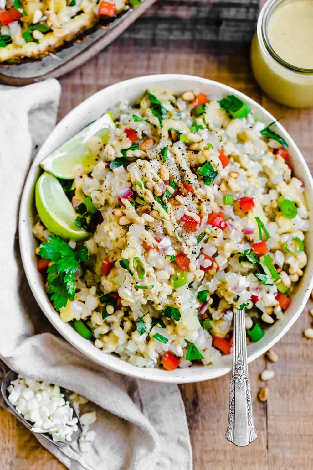 Cauliflower Rice Salad garnished with lime and fresh herbs