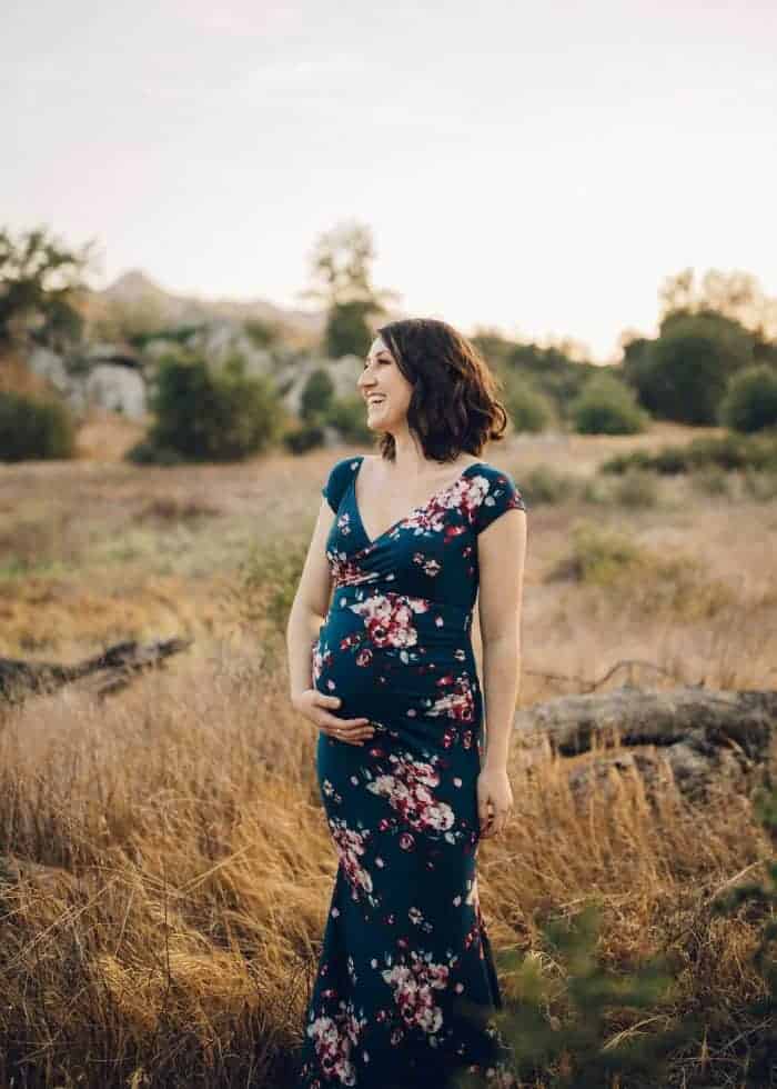 Happy pregnant woman outside smiling 