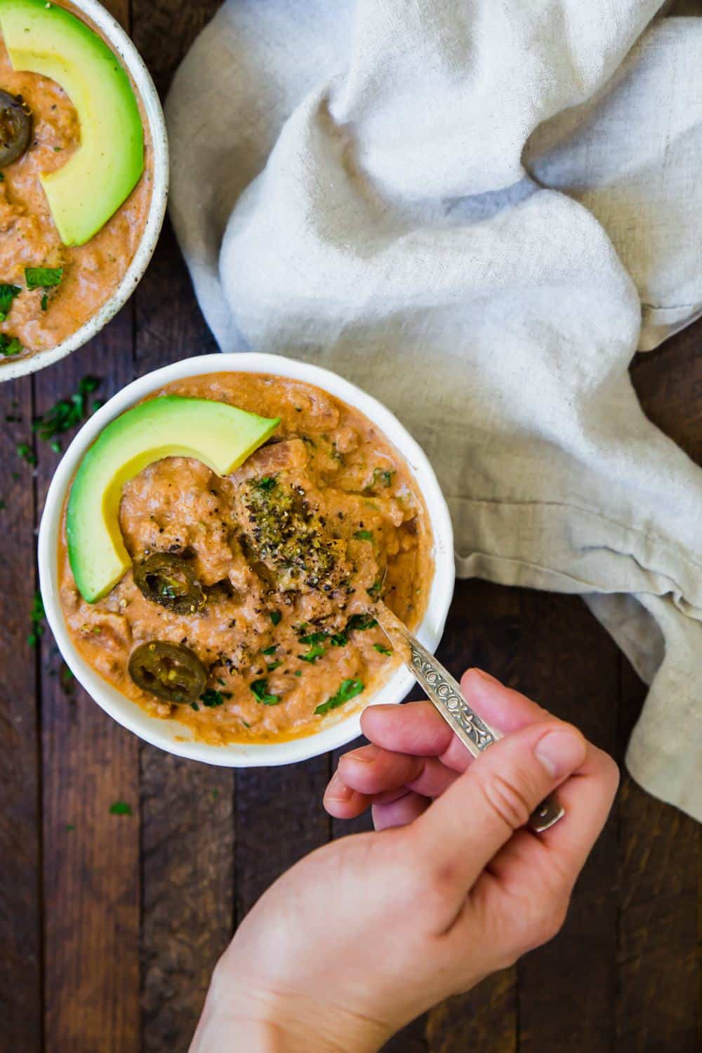 hand scooping from a bowl of low carb cheeseburger soup