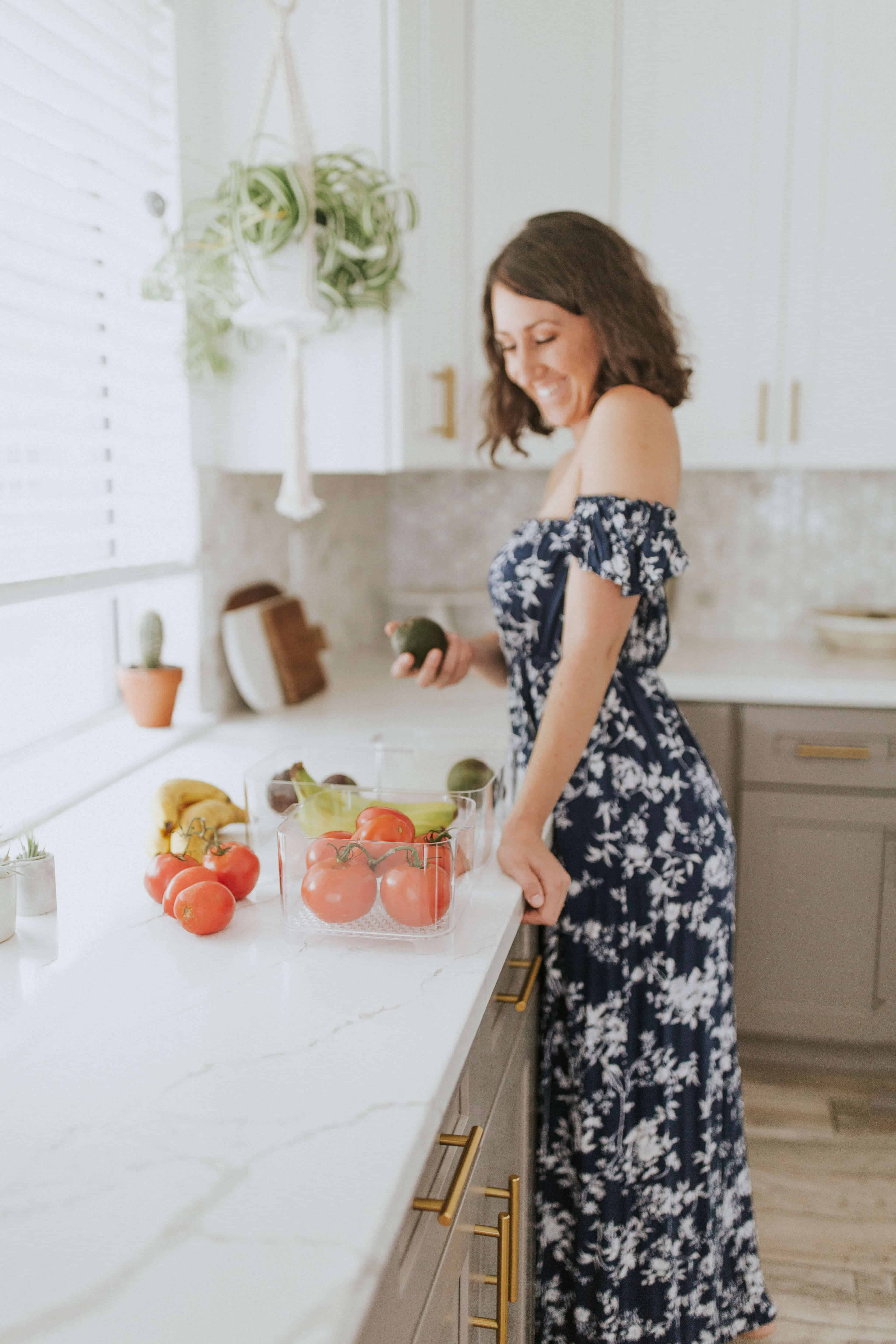 Woman holding an avocado in a kitchen