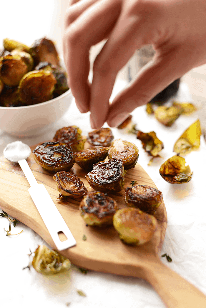 Charred balsamic Brussel sprouts with sea salt on a wooden board