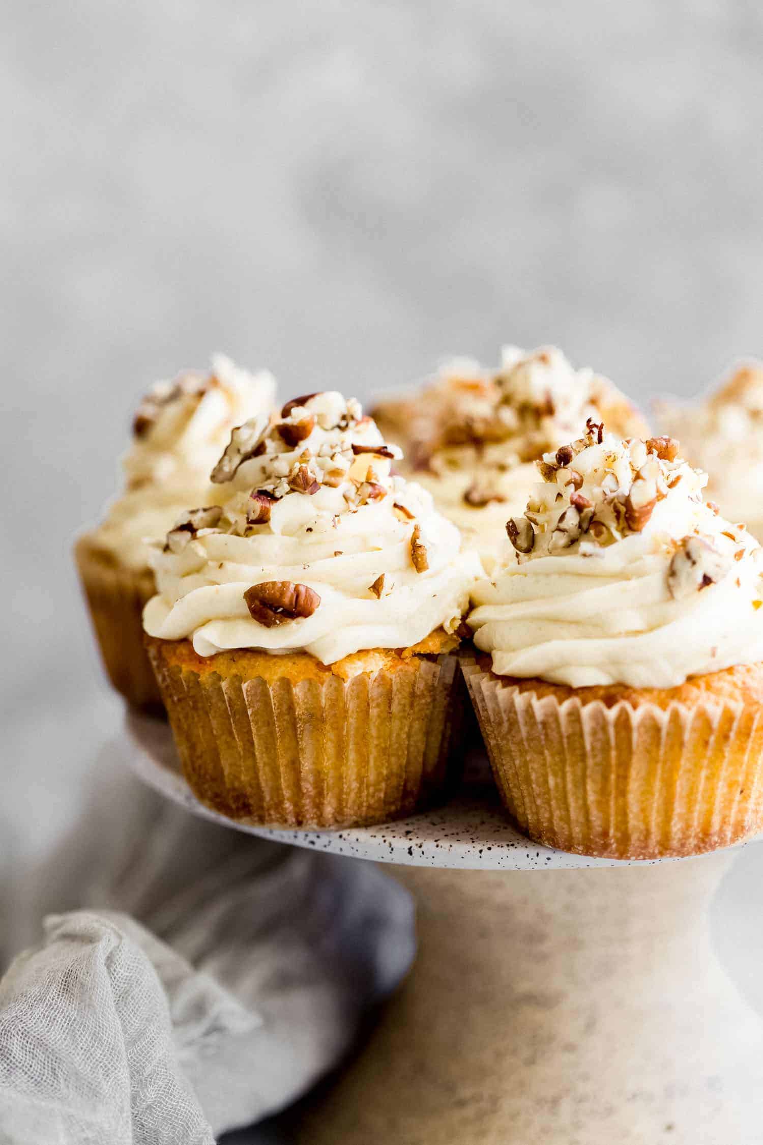 keto carrot cake cupcakes on a cake stand