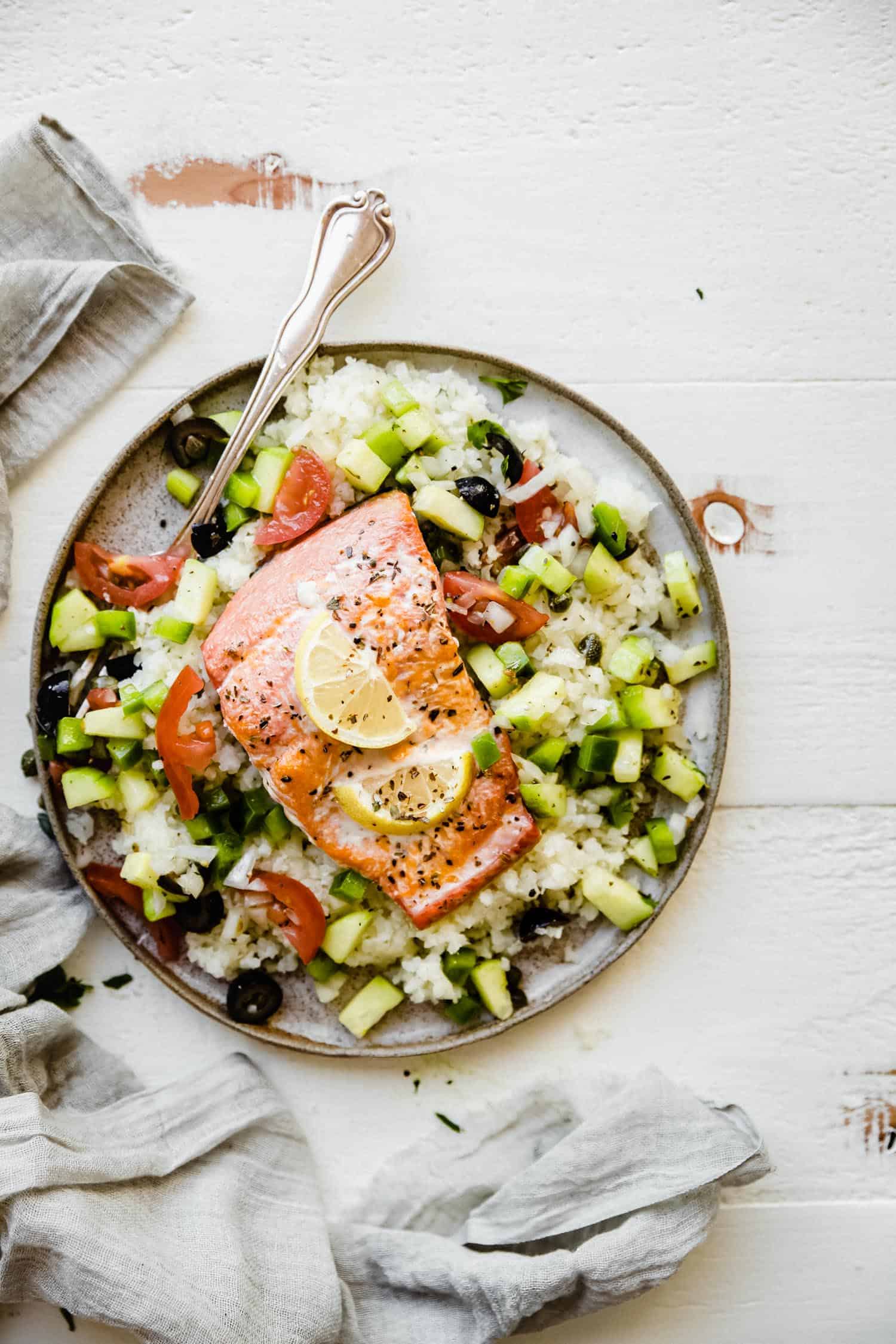 Whole30 Greek salmon on a plate with cauliflower rice and salad