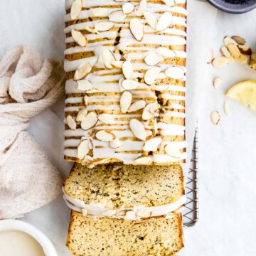 overhead shot of keto lemon poppy seed bread with coconut butter glaze drizzled on top and sliced almonds