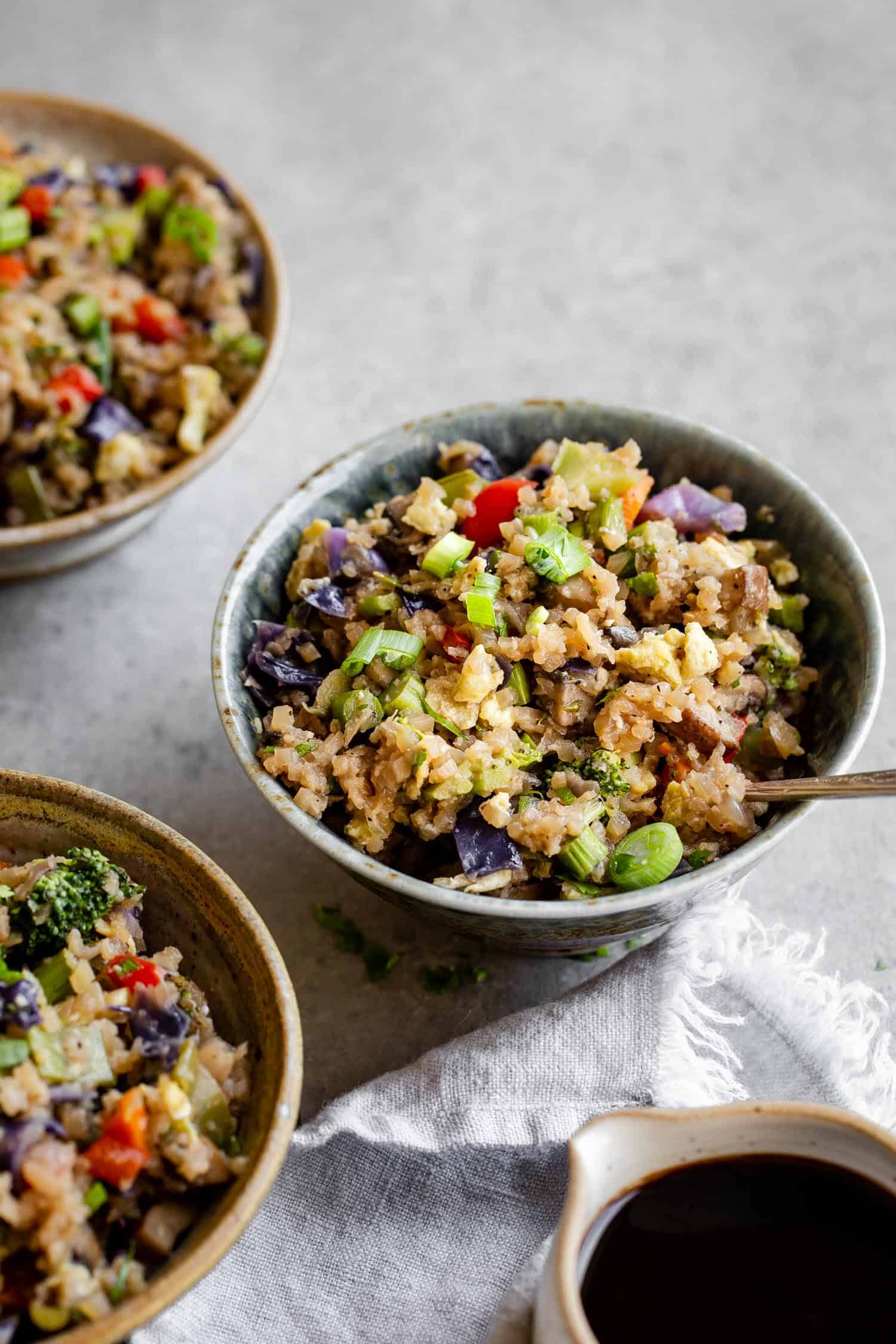 Asian cauliflower fried rice in a bowl with a spoon