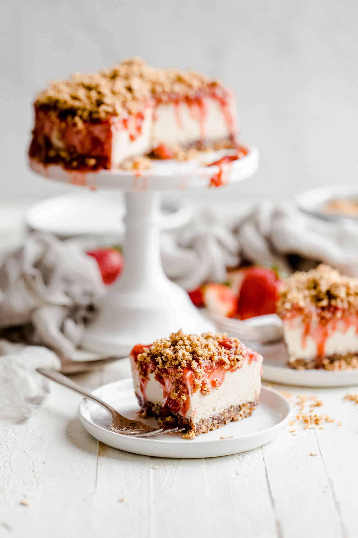 slice of vegan strawberry cheesecake on a white plate