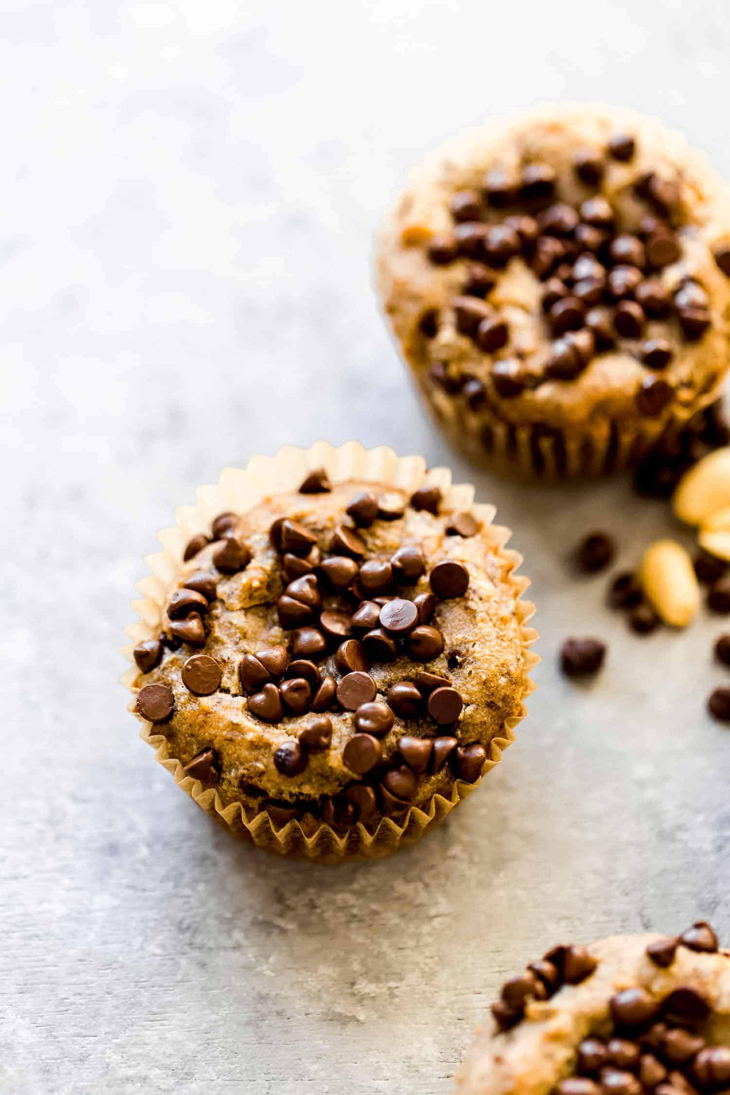 two peanut butter banana muffins with chocolate chips on top