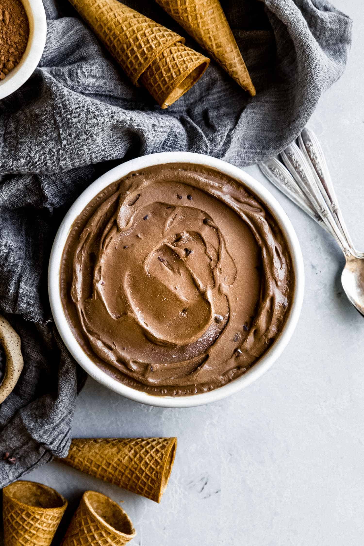 creamy chocolate ice cream in a circular pan with cones on the side
