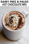paleo hot chocolate in a white mug with whipped cream and chocolate on top