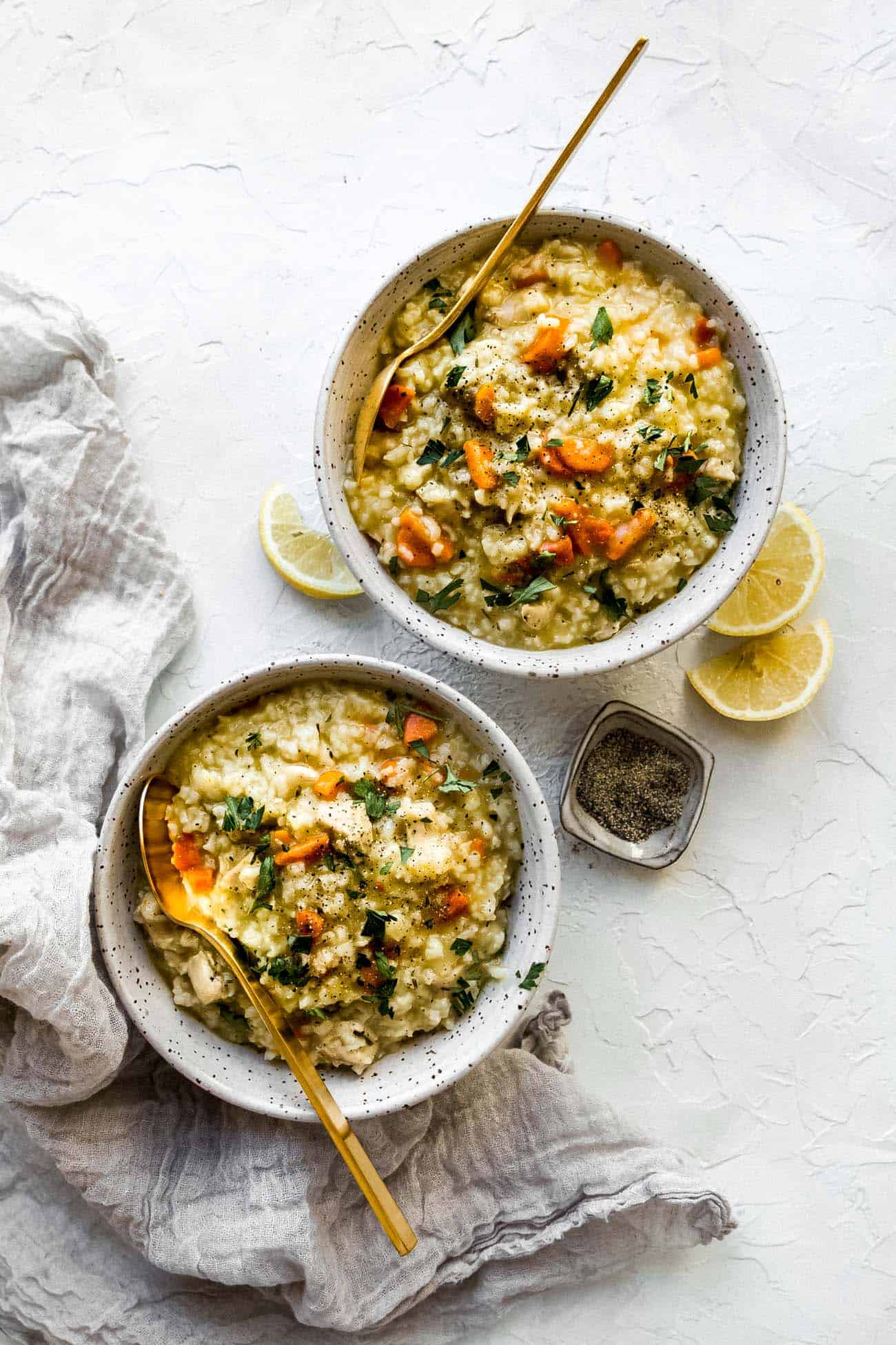 two bowls of Instant Pot chicken and rice with gold spoons inside