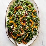 delicata squash salad on a large platter with a serving spoon