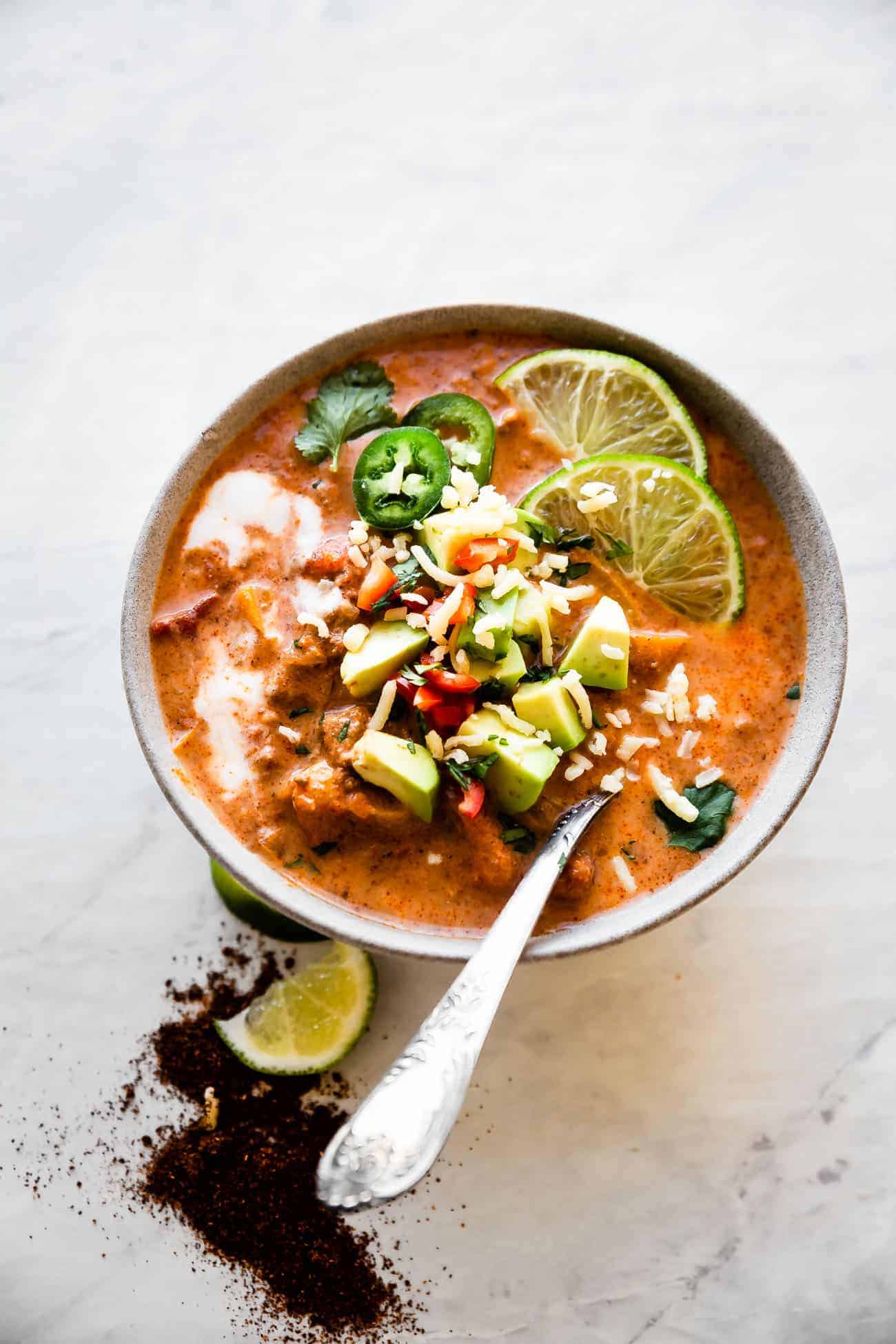 one bowl of Whole30 creamy taco soup on a marble board with avocado on top