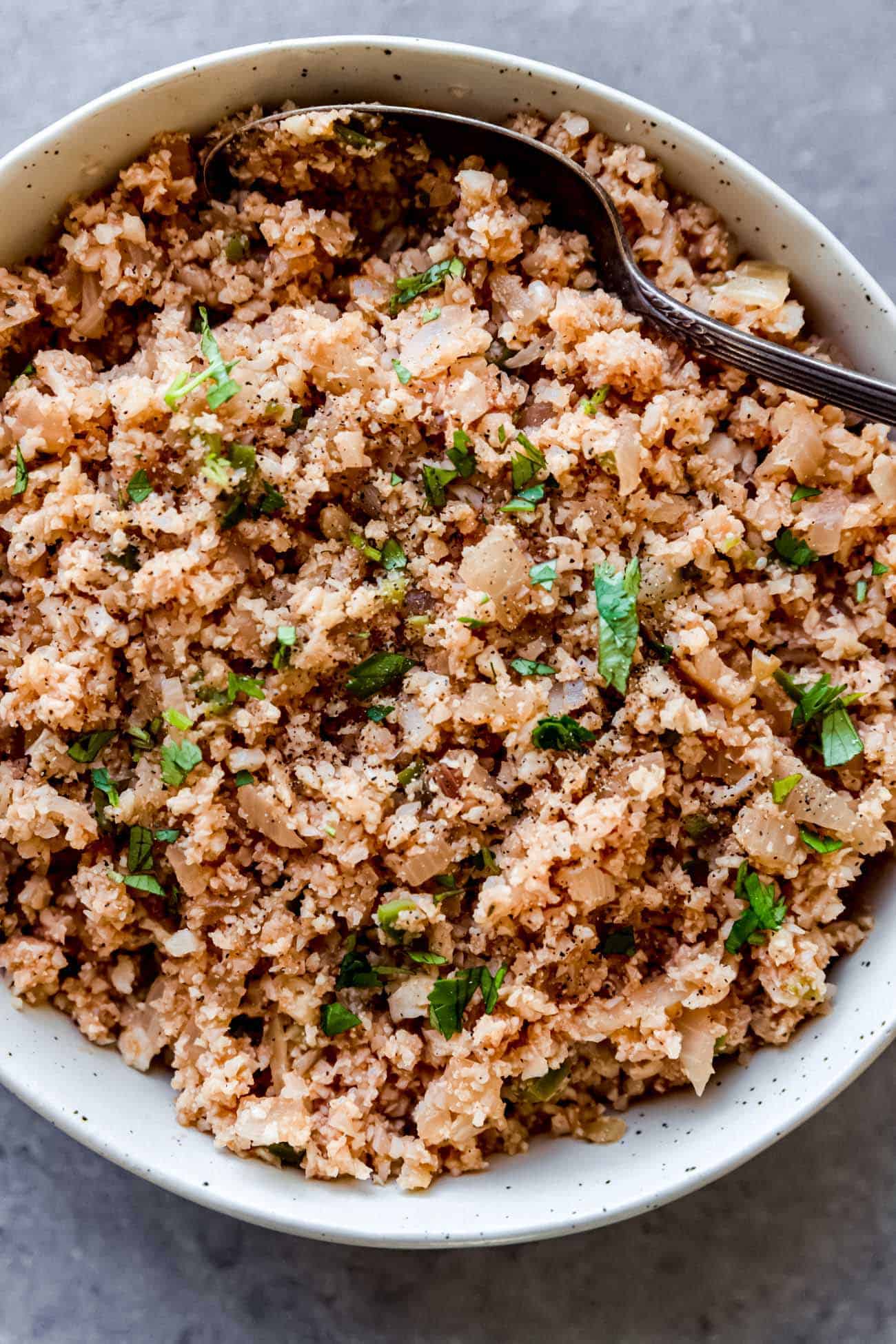 Spanish cauliflower fried rice in a bowl with a spoon inside